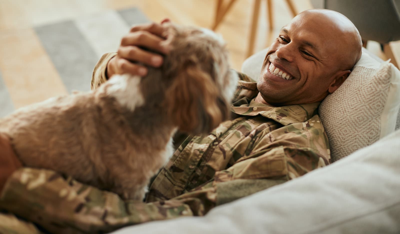 military veteran on couch with a dog